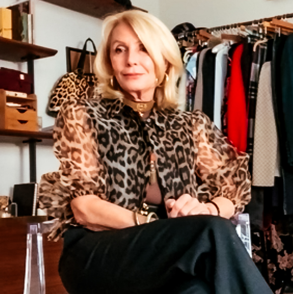 Fashion Blogger Sonia Lovett wears a sheer leopard-print blouse seated in her closet
