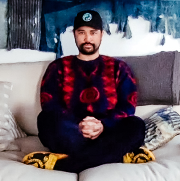 Podcaster James Harris wears a graphic sweater seated on a couch