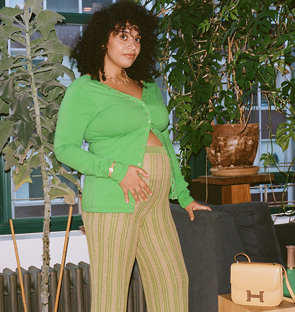 Mother's Day Feature: Collier Meyerson, one of three moms in different stages of life with their children wearing designer clothes. pregnant, standing, wearing a green sweater and beige pants with an Hermes Constance bag Photograph by Mary Manning
