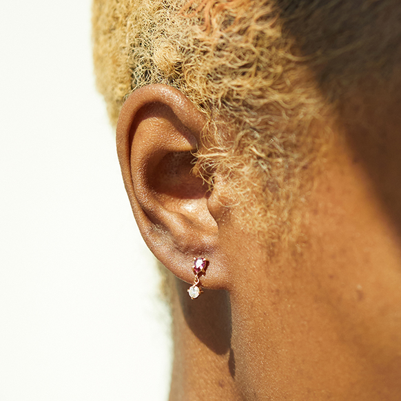 The RealReal x Catbird. Model wearing Mismatched Angel Hair Stud earring in gold with ruby and diamonds, sustainable jewelry from upcycled collection